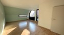 Wohn- und Esszimmer mit Zugang zum teilüberdachten Balkon