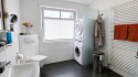 Badezimmer mit ebenerdiger Dusche und Waschmaschinenanschluss