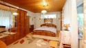 Schlafzimmer (EG) mit Zugang zum Wintergarten und rückwärtigem Gartenbereich  (mit KI bearbeitet)